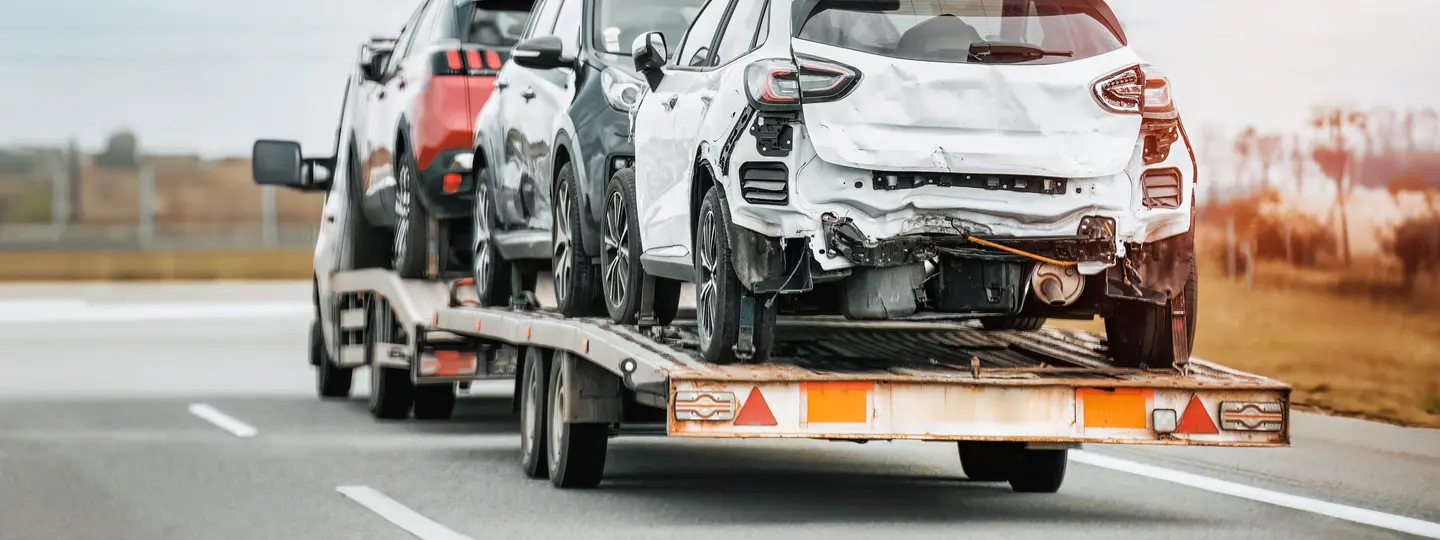 Schrottreife Autos auf Fahrzeugtransporter